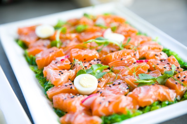 salmon with greens and quail eggs on banquet table